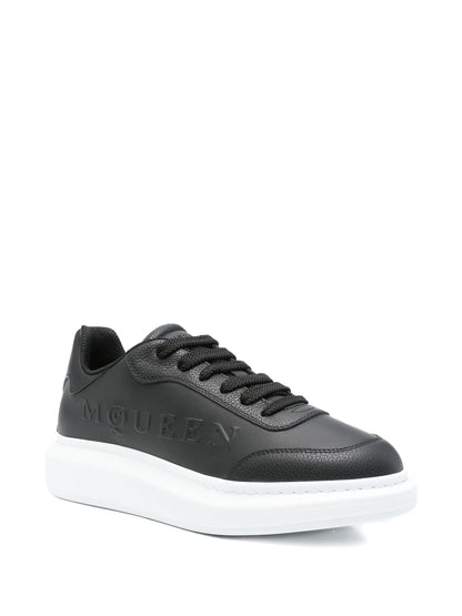 Sneakers Alexander McQueen nere con logo goffrato e piattaforma